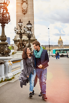 Buy stock photo Shot of a smiling young couple walking together in the streets of Paris