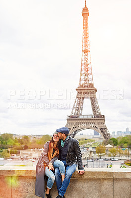 Buy stock photo Shot of a happy young couple sitting together in front of the Eiffel Tower