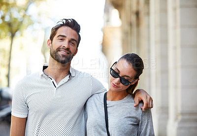Buy stock photo Portrait of an affectionate young couple walking together in the city