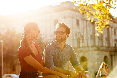 Buy stock photo Shot of an affectionate young couple enjoying a day together in the city