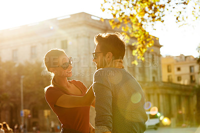 Buy stock photo Shot of an affectionate young couple enjoying a day together in the city