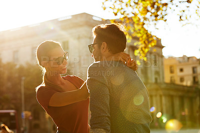 Buy stock photo Shot of an affectionate young couple enjoying a day together in the city