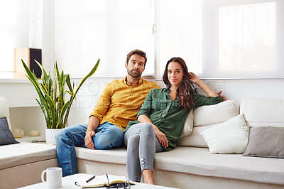 Buy stock photo Portrait of a young couple relaxing together on their living room sofa