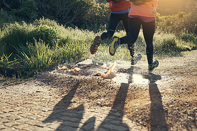 Buy stock photo Cropped shot of two friends' legs while out for a run together on a cool morning