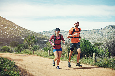 Buy stock photo Shot of two young friends running together along a path outdoors