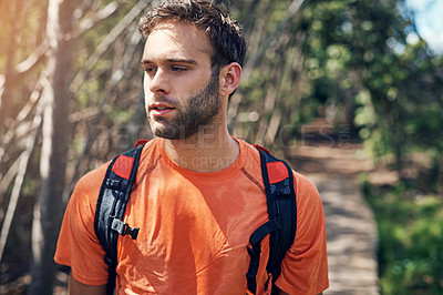 Buy stock photo Shot of a focused young man out for a run on a trail in a forest