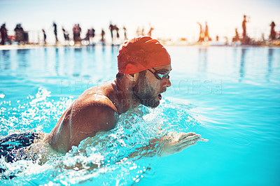 Buy stock photo Shot of an athletic young man swimming in a pool