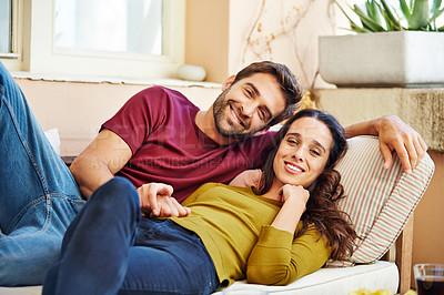 Buy stock photo Portrait of a young couple relaxing together on their living room sofa