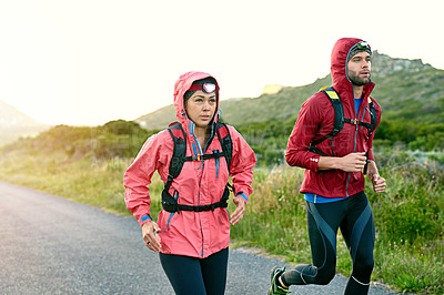 Buy stock photo Shot of two friends out for a run together on a cool morning