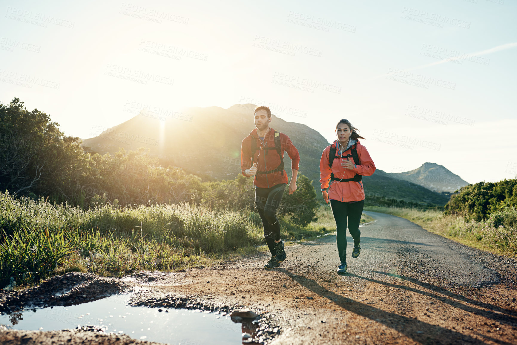Buy stock photo Shot of two friends out for a run together on a cool morning
