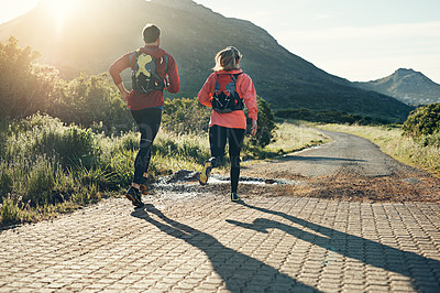 Buy stock photo Rearview shot of two friends out for a run together on a cool morning