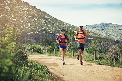Buy stock photo Shot of two young friends running together along a path outdoors