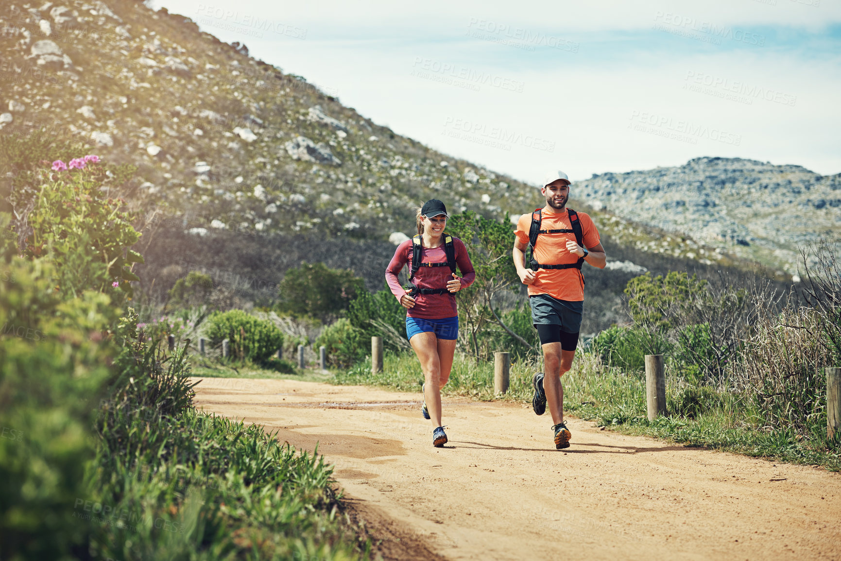 Buy stock photo Running, happy couple and fitness outdoor for workout, cardio or wellness training with space. Smile, man and woman jog in nature to exercise with partner, heart health and endurance by mountain path