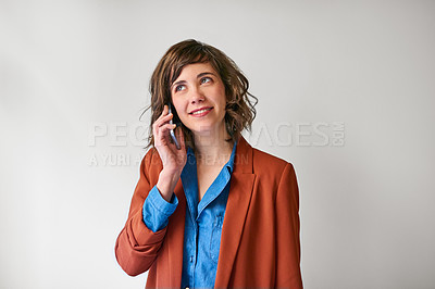 Buy stock photo Shot of an attractive young woman using her cellphone against a grey background