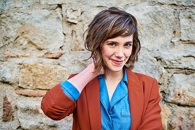 Buy stock photo Shot of an attractive young woman standing outdoors against a rocky wall