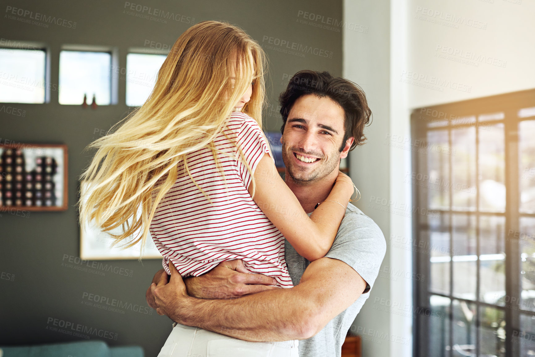 Buy stock photo Smile, couple and spinning in home with hug, good news and playful morning for anniversary fun. Portrait, people and playing at house with embrace, partner support and energy for marriage celebration