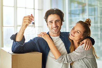 Buy stock photo Shot of an affectionate young couple holding up the keys to their new home