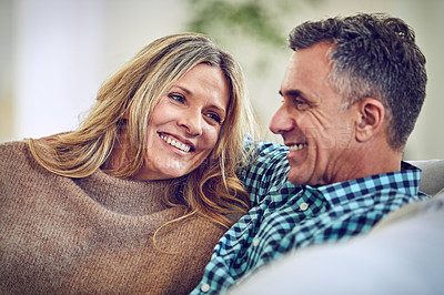 Buy stock photo Shot of an affectionate mature couple sitting on the sofa at home