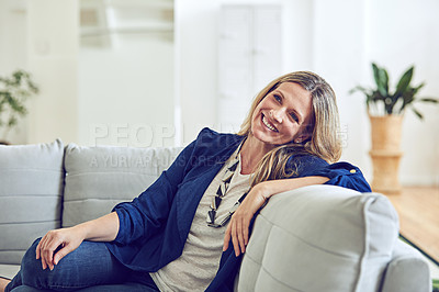 Buy stock photo Shot of an attractive and mature woman relaxing on the sofa at home