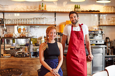 Buy stock photo Shot of a confident man and woman working together in a coffee shop