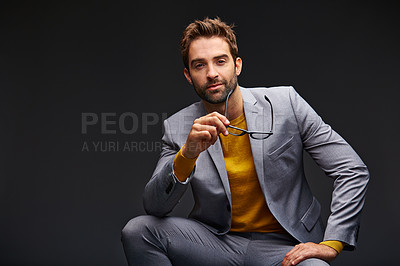 Buy stock photo Studio portrait of a handsome young man posing against a dark background