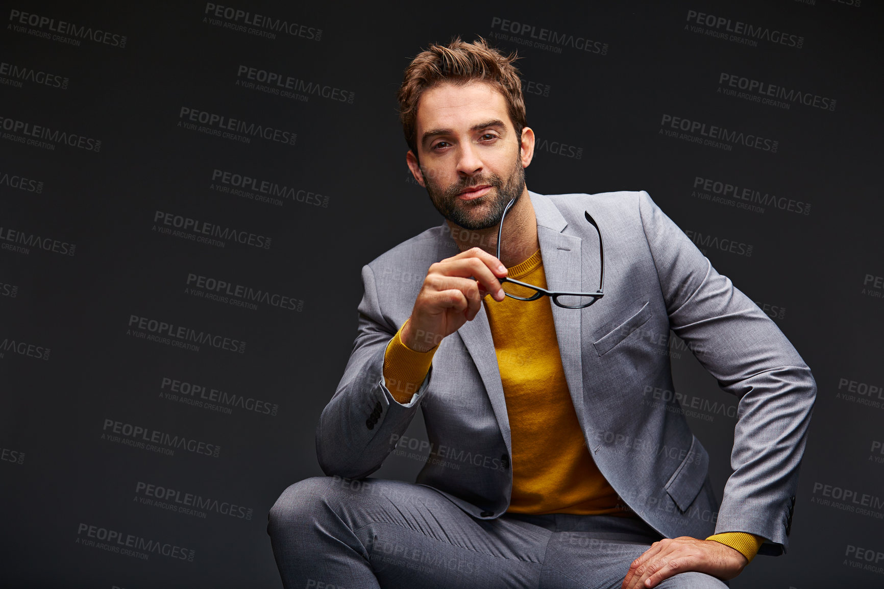 Buy stock photo Studio portrait of a handsome young man posing against a dark background