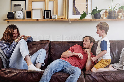 Buy stock photo Shot of a happy young family playing around on the sofa at home