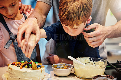 Buy stock photo Shot of a young father baking a cake with his son and daughter