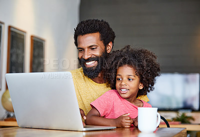 Buy stock photo Shot of a cheerful young father and son browsing on a digital tablet together while being seated at a table in their home
