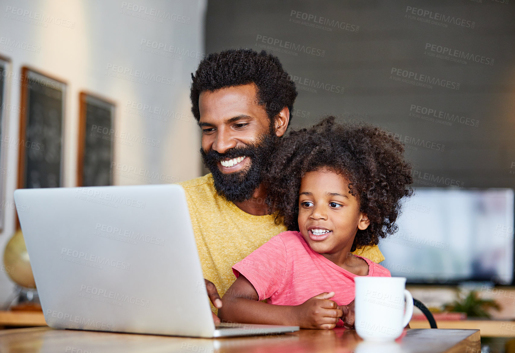 Buy stock photo Shot of a cheerful young father and son browsing on a digital tablet together while being seated at a table in their home