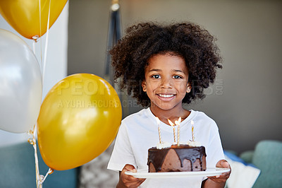 Buy stock photo Portrait of a cheerful young little boy holding a cake with balloons next to him inside at home during the day
