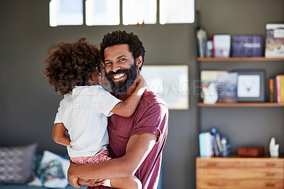 Buy stock photo Portrait of a cheerful young father holding his son while looking at the camera inside at home during the day