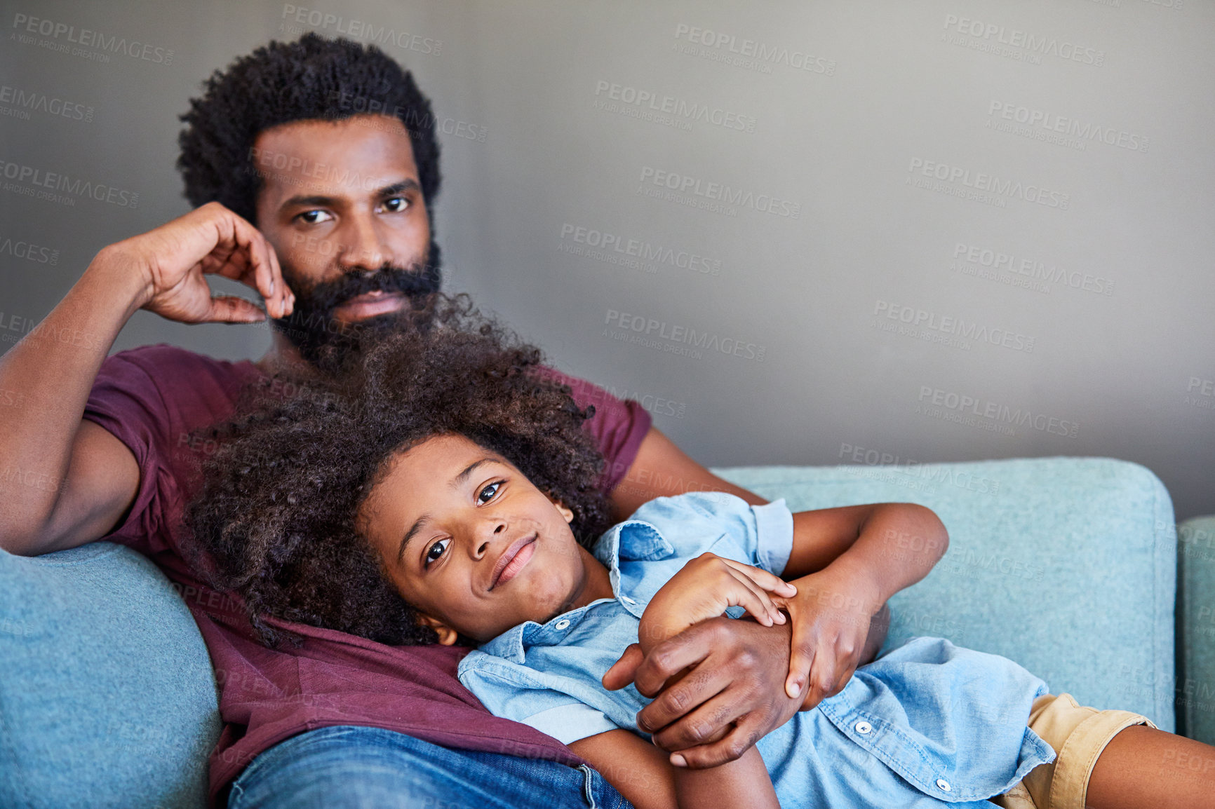 Buy stock photo Portrait of a cheerful father and son lying down and relaxing on the couch at home during the day