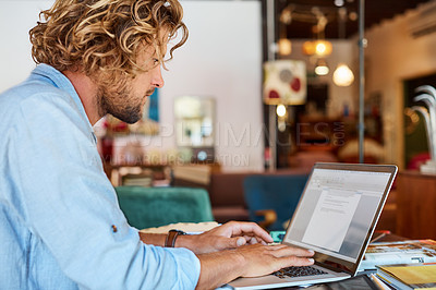 Buy stock photo Cropped shot of a man working on his laptop in a modern office