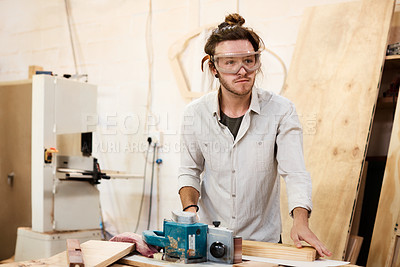 Buy stock photo Shot of a man working with wood in a furniture manufacturing workshop