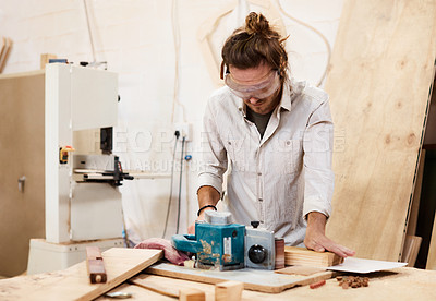 Buy stock photo Shot of a man working with wood in a furniture manufacturing workshop