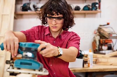 Buy stock photo Shot of a woman working with wood in a furniture manufacturing workshop