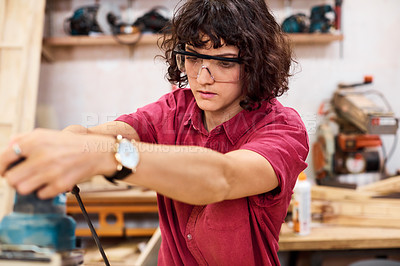 Buy stock photo Shot of a woman working with wood in a furniture manufacturing workshop