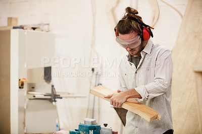 Buy stock photo Shot of a man working with wood in a furniture manufacturing workshop