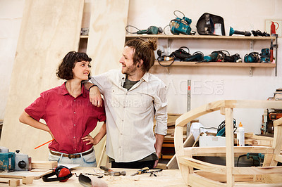 Buy stock photo Shot of two people working with wood in a furniture manufacturing workshop