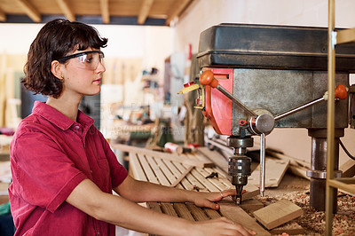 Buy stock photo Shot of a woman working with wood in a furniture manufacturing workshop