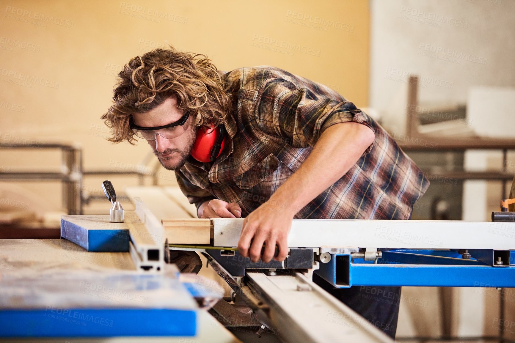 Buy stock photo Shot of a man working with wood in a furniture manufacturing workshop