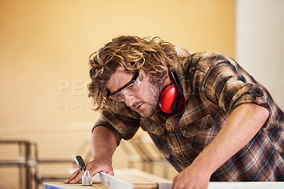 Buy stock photo Shot of a man working with wood in a furniture manufacturing workshop