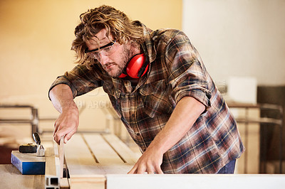 Buy stock photo Shot of a man working with wood in a furniture manufacturing workshop