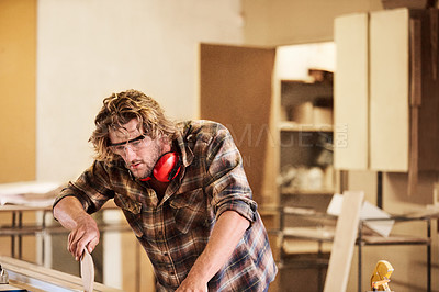 Buy stock photo Shot of a man working with wood in a furniture manufacturing workshop