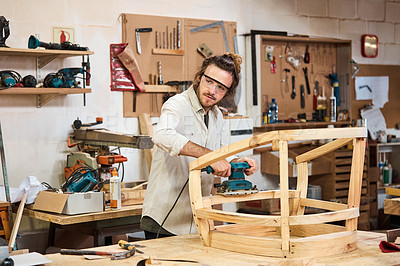 Buy stock photo Shot of a man working with wood in a furniture manufacturing workshop