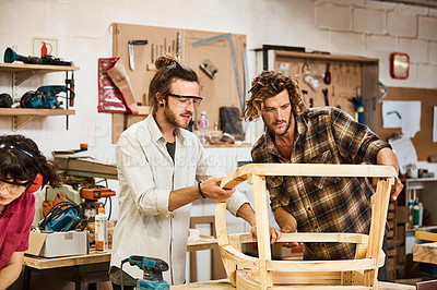 Buy stock photo Shot of three people working with wood in a furniture manufacturing workshop