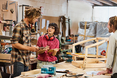 Buy stock photo Shot of three people working with wood in a furniture manufacturing workshop