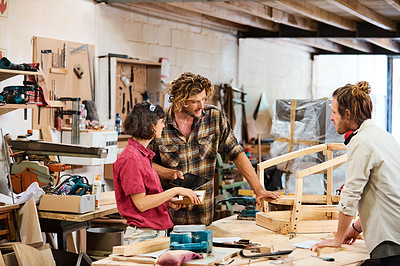 Buy stock photo Shot of three people working with wood in a furniture manufacturing workshop