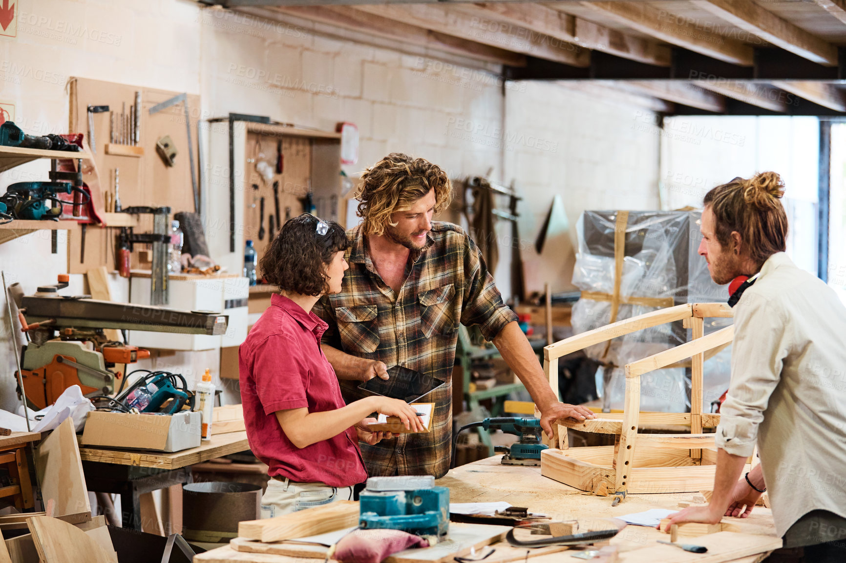 Buy stock photo Woodworking, people and teamwork with tablet, workshop and plan for furniture design and discussion. Carpenter, collaboration and conversation in woodshop, men and woman with notebook for project